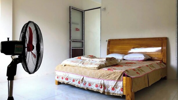 Un dormitorio con cama, un ventilador y una puerta con el número 304.