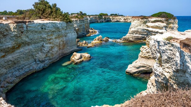 Un paysage côtier caractérisé par des falaises rocheuses et des eaux turquoise cristallines.