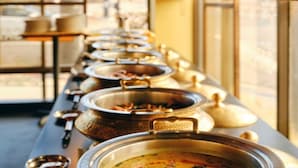 Un buffet avec de nombreux plats différents présentés dans des récipients séparés.