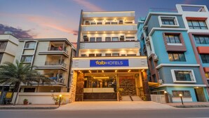 A multi-story hotel with a prominent 'fabHOTELS' sign, featuring a modern facade with balconies and a well-lit entrance.