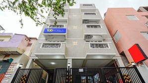 A multi-story hotel with a prominent 'FabHotels' sign, a gated entrance, and a staircase leading to the upper floors. - Fabhotel Lucky Inn Grand Residency (Chennai)