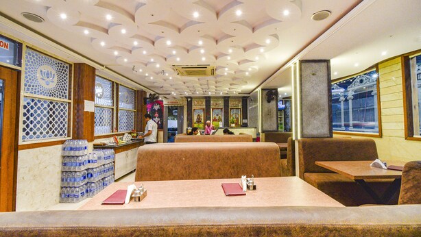 A restaurant with booths and tables, a water dispenser, and a ceiling with recessed lighting. - Fabhotel Yogeshwara Grand (Hyderabad)