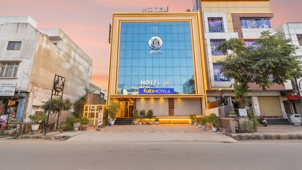 A modern hotel building with a prominent glass facade and a sign reading "HOTEL JBS". - Fabhotel Lfc (Jaipur)