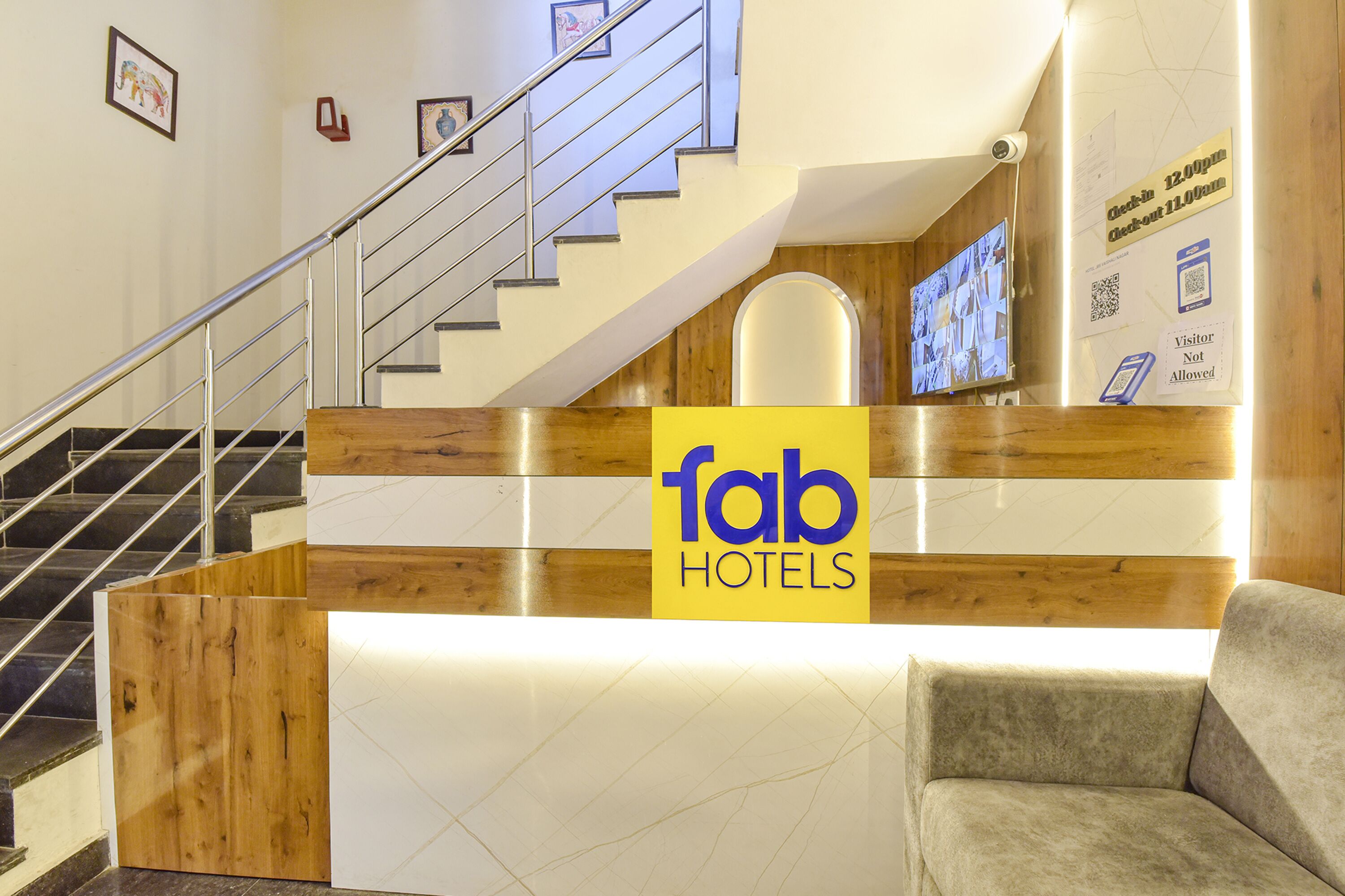 En receptionsdisk med träpanel och en skylt med texten ”fab hotels”.