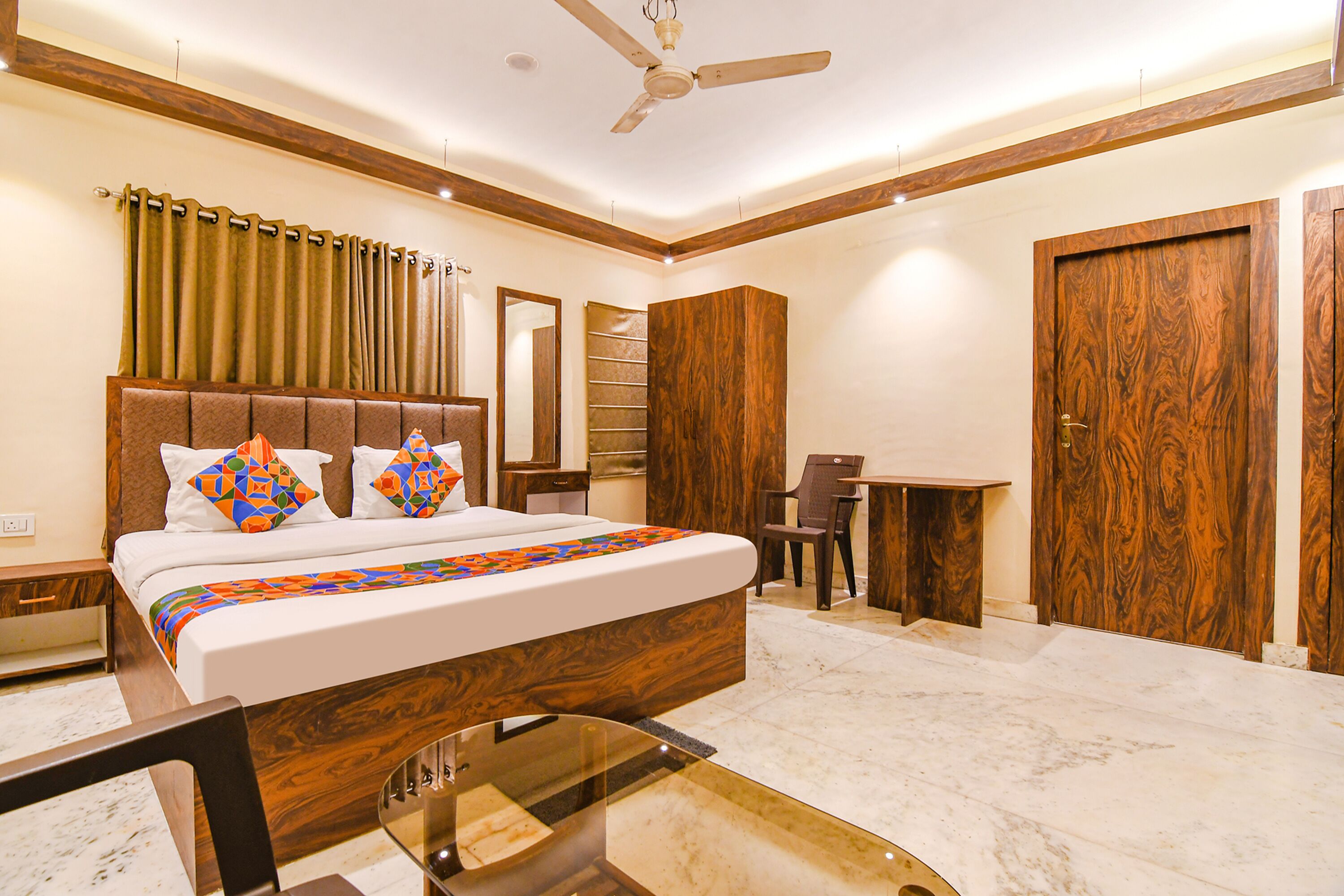 A hotel room with a large bed, a desk, and a chair.
