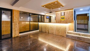 A reception area with wooden paneling, a reception desk, and a clock on the wall.
