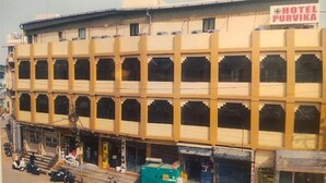 A multi-story hotel with a yellow facade and multiple balconies. - Fabhotel Purvika (Varanasi)