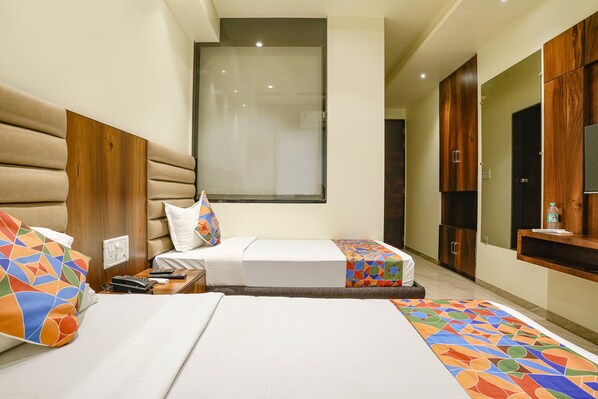 A hotel room with two beds, a large window, wooden headboards, a TV, and a minibar. - Fabhotel Prime Majhali (Nashik)