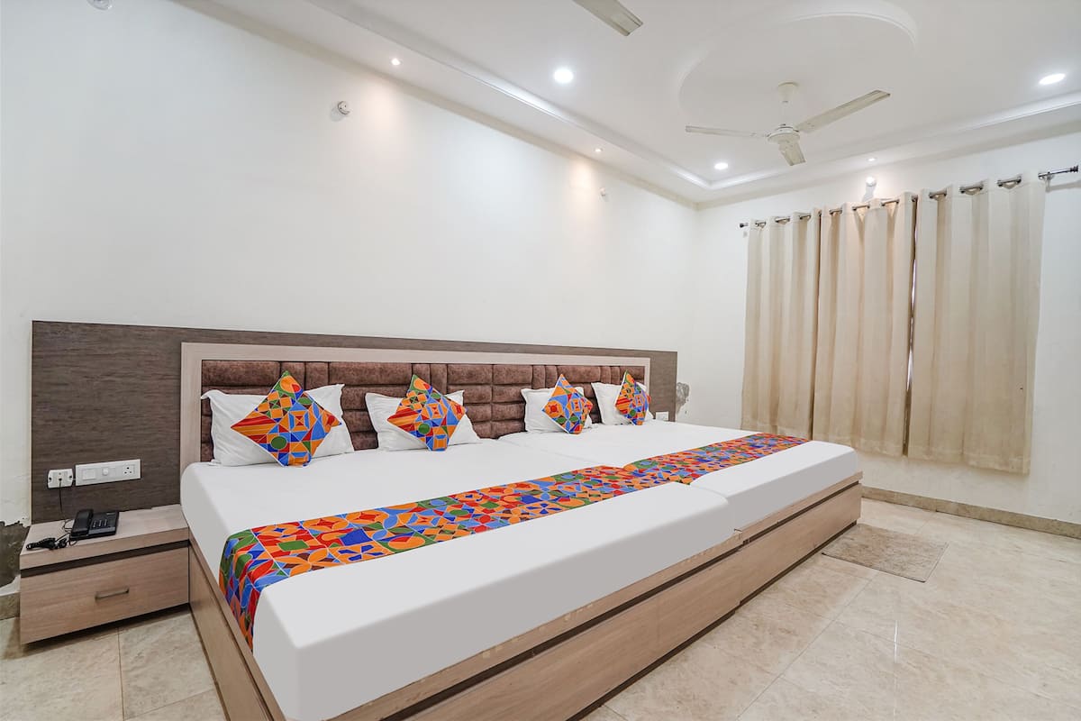 Une chambre moderne avec un grand lit, une tête de lit en bois et un ventilateur de plafond.