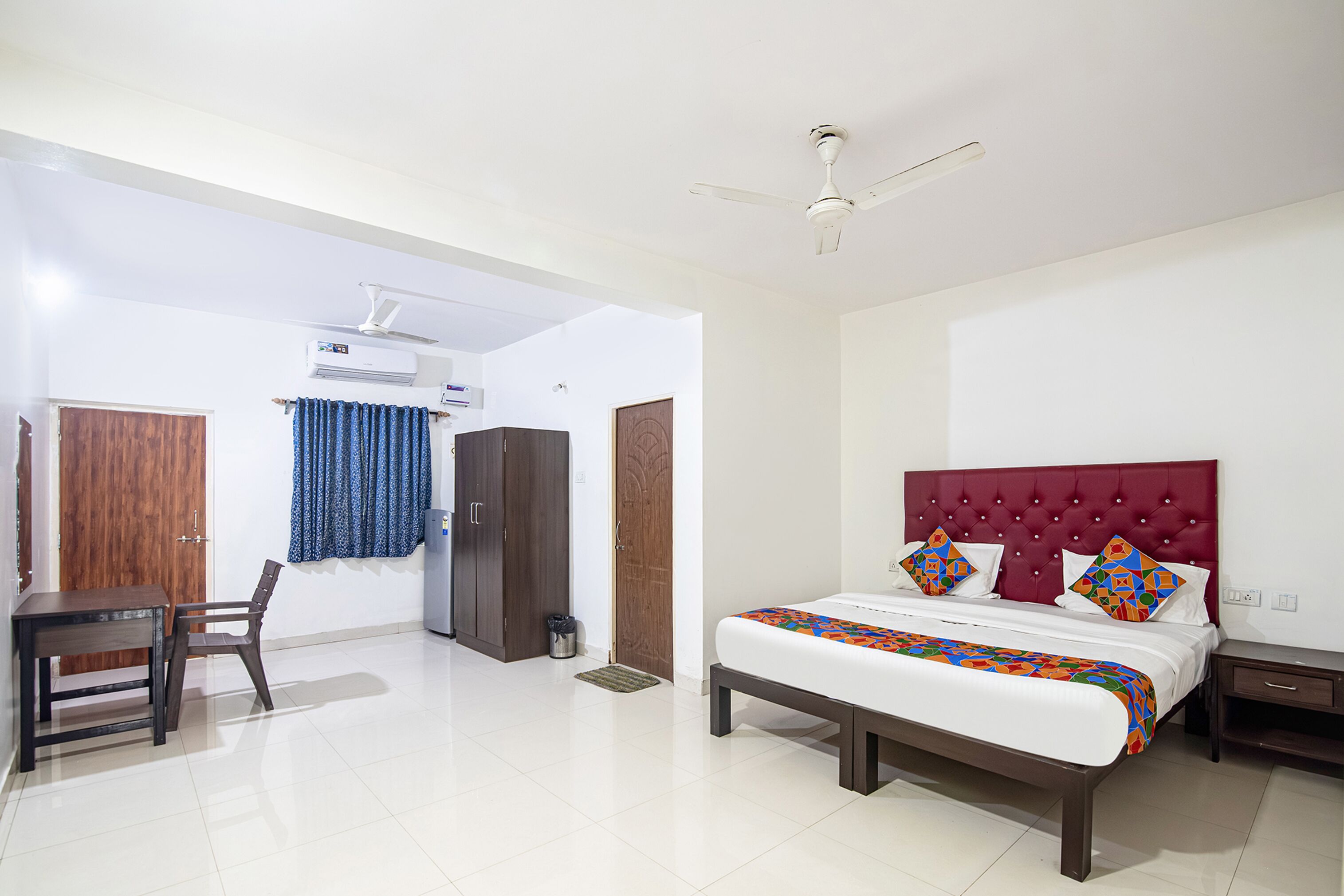 A bedroom with a bed, a desk, and a chair.