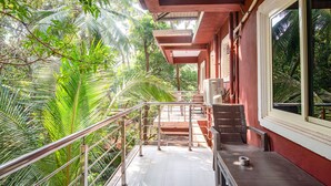 A balcony with a metal railing, a staircase, and a view of lush greenery. - FabHotel Noronha Goaxa Inn - Nr. Calangute beach (Calangute)
