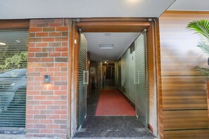 A hallway with a red carpet leading to a door with a sign reading "CH 730". - Fabhotel Ample Yard (Chennai)
