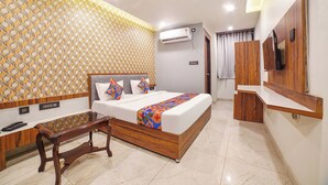 Une chambre d’hôtel équipée d’un lit, d’un bureau, d’une télévision et d’un climatiseur.