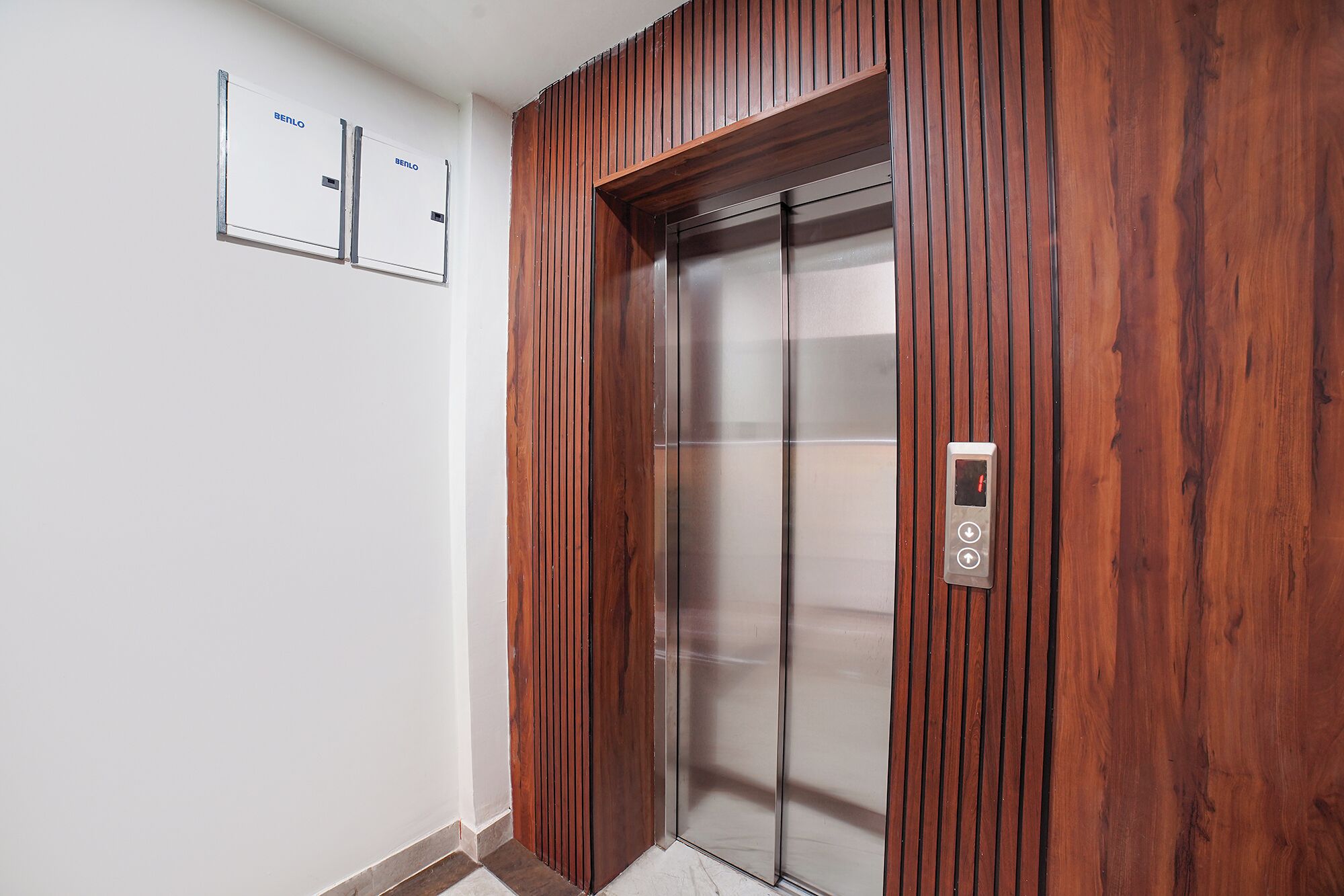 Un ascensor con paneles de madera, un panel de control y un letrero en la pared.