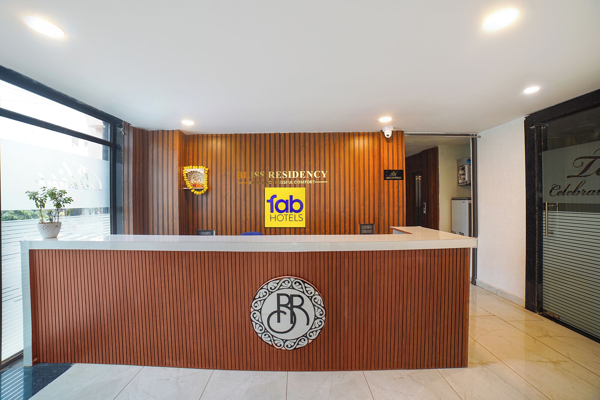 A reception desk with a wooden finish, a logo, and a sign for 'Fab Hotels'.