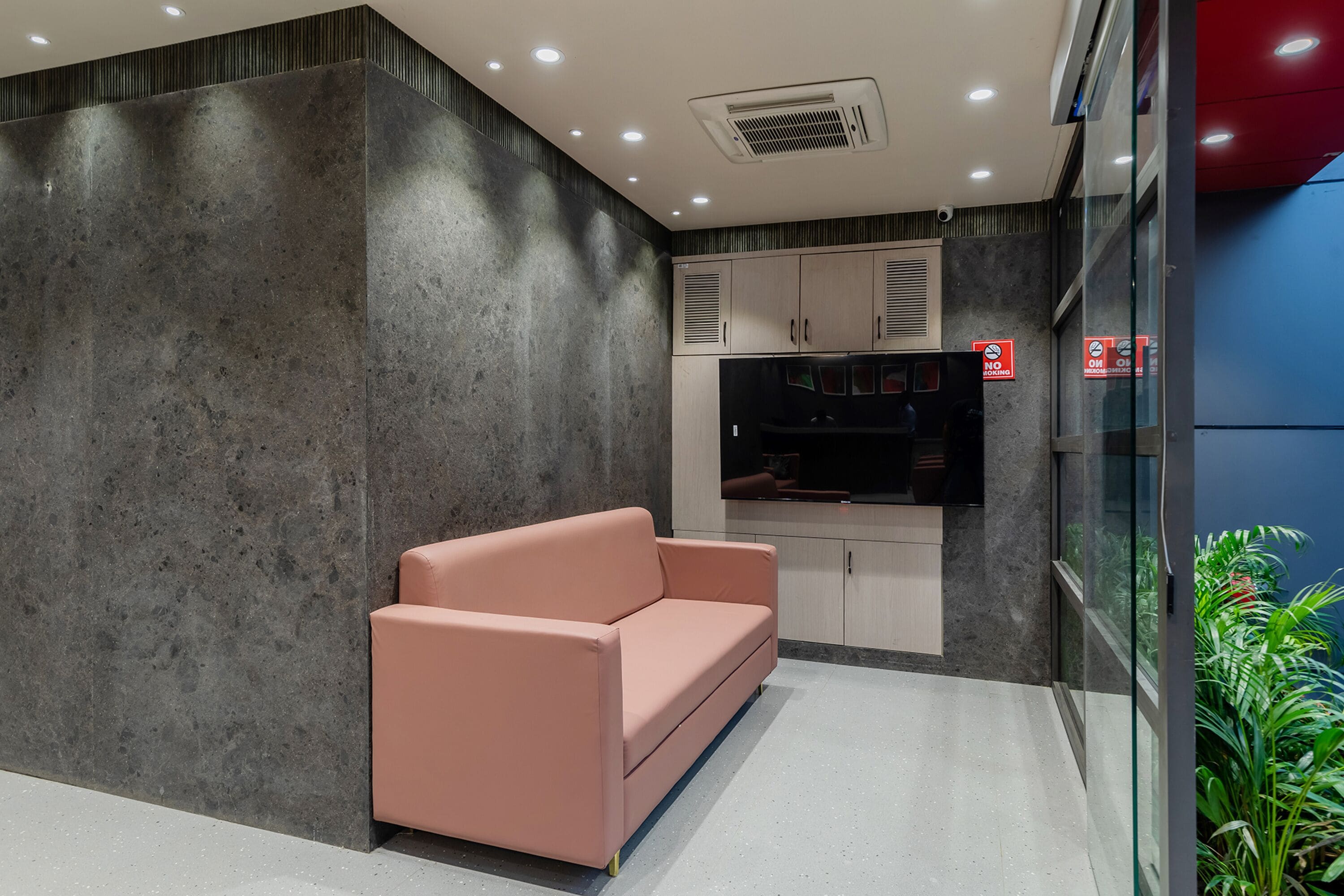 A modern interior with a sofa, cabinets, and a TV.