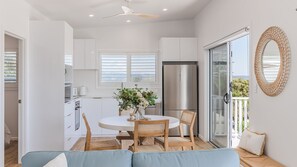 Enjoy meals at the round dining table, surrounded by natural light and a stylish mirror.