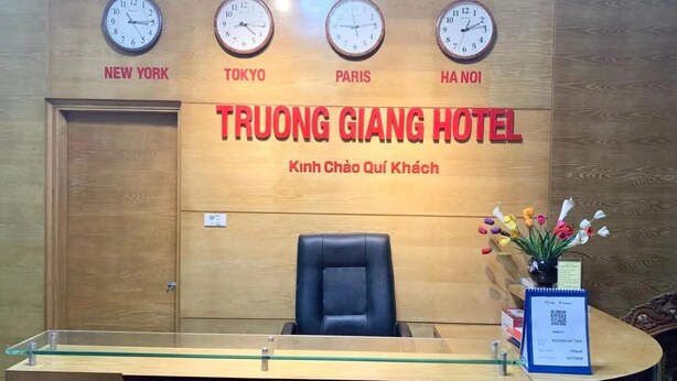 En hotellreception med klockor som visar aktuell tid för New York, Tokyo, Paris och Hanoi.