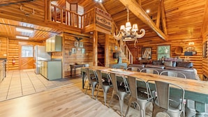 A log cabin with a dining area, kitchen, and living room.