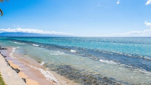 A beach with clear turquoise waters and a sandy shore.