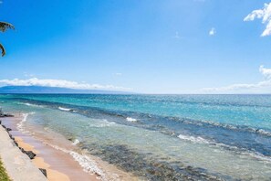 Una playa con aguas turquesas cristalinas y una orilla arenosa.