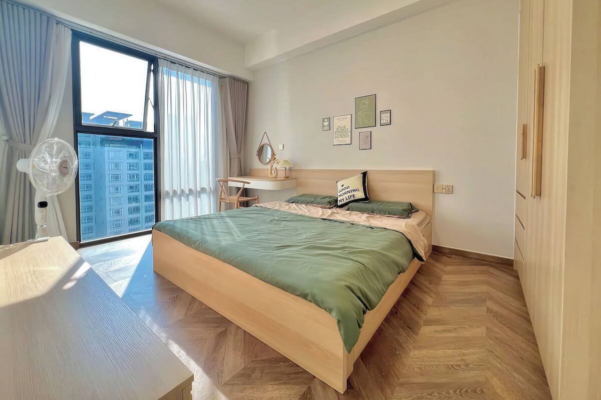 Ein modernes Schlafzimmer mit einem großen Bett, einem Schreibtisch und einem Fenster mit Vorhängen.