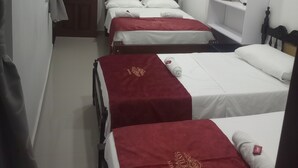 A hotel room with three single beds, a ceiling fan, an air conditioner, and a door with a number. - Hotel Santa Bárbara Mompos (Mompos)