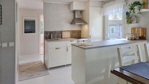 Una cocina moderna con armarios blancos, una isla central y una ventana con vistas.
