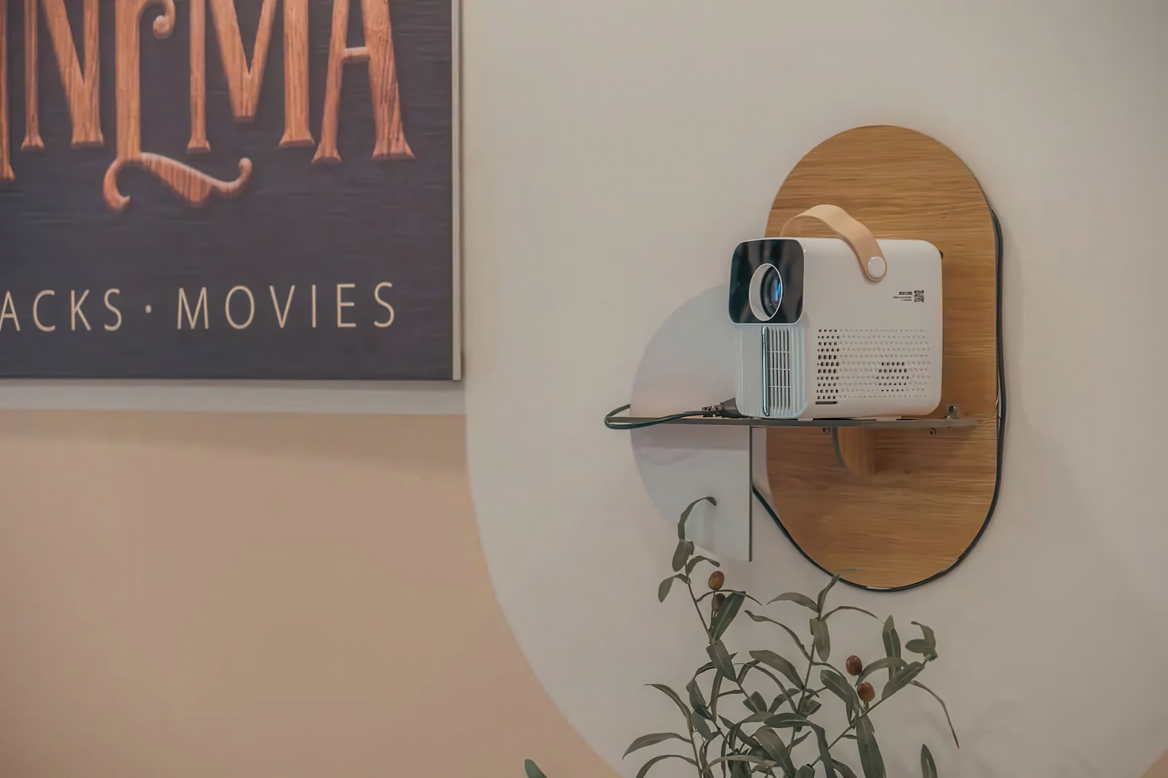 A projector on a wooden shelf against a wall with a cinema-themed sign.