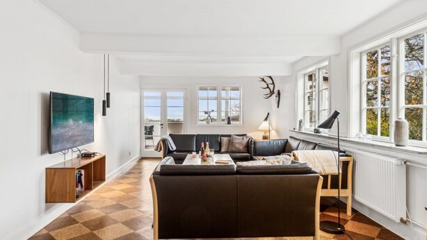 A modern living room with a checkered floor, a large flat-screen TV, a sofa, and a dining area with a table and chairs. - "Garbine" - 1.5km from the sea by Interhome (Østermarie)