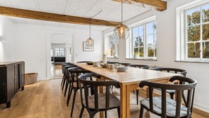 A spacious dining area with a long wooden table, black chairs, and pendant lighting. - "Garbine" - 1.5km from the sea by Interhome (Østermarie)