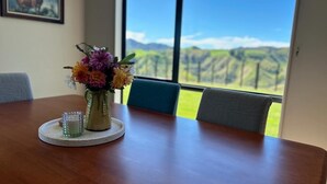 A dining table with a vase of flowers and a glass of water.
