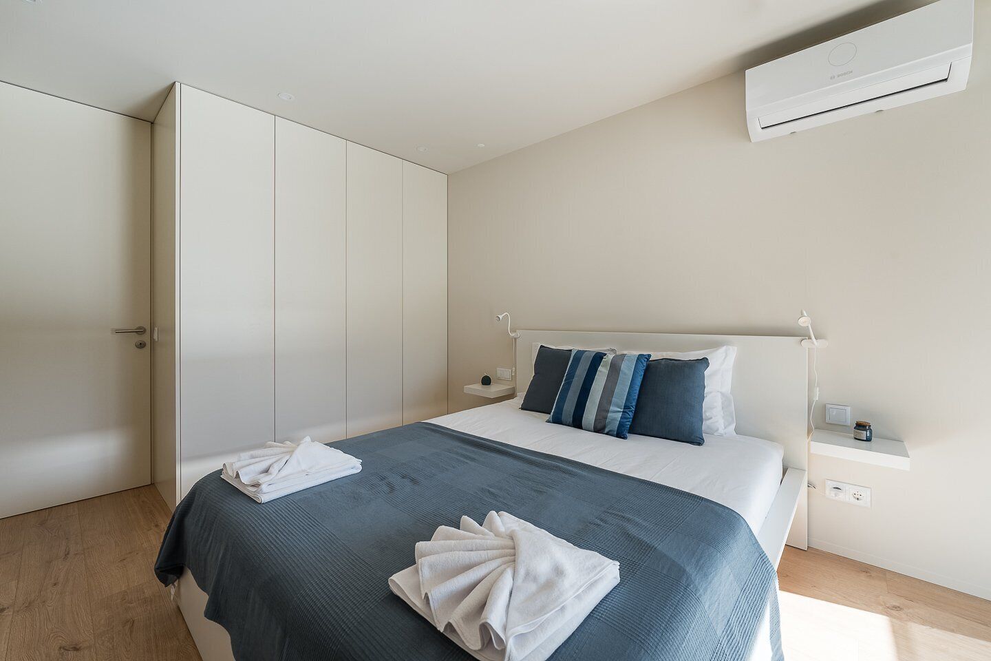 Une chambre à coucher comprenant un lit, une armoire, une table de chevet et un appareil de climatisation.