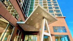 Un edificio moderno con una destacada estructura en forma de A, amplios ventanales de vidrio y un cielo despejado.