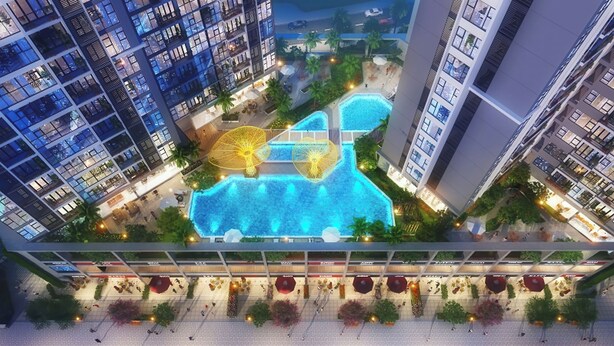 Vista aérea de un hotel moderno con varios edificios de gran altura, una piscina central y zonas de estar al aire libre.