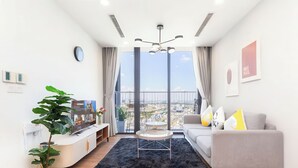 Un salón moderno con un ventanal grande, un sofá, una mesa de centro y una planta.