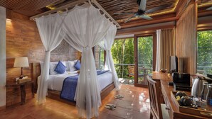 A bedroom with a canopy bed, a television, a coffee maker, and a view of the outdoors. - Sacred Valley by GenuineHost (Sebatu)