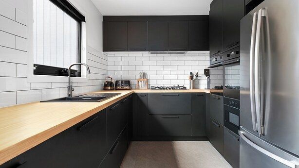 A modern kitchen with black cabinets, a stainless steel refrigerator, and a wooden countertop. - Snowbound 2 - Family Ski Chalet, 5 minute walk to the slopes (Thredbo)
