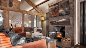 A cozy living room with a stone fireplace, a large mirror, and a comfortable seating area. - Mead Cottage | Ridgestone (Lindale)