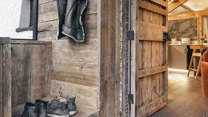 A rustic wooden interior with a bench and a pair of boots. - Mead Cottage | Ridgestone (Lindale)