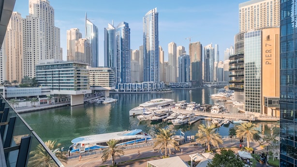 A marina with yachts docked, surrounded by high-rise buildings and palm trees. - Stylish Marina-Front 2BR | Dubai Marina | Near Top Attractions (Dubai)