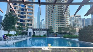 A swimming pool with a view of tall buildings in the background. - Stylish Marina-Front 2BR | Dubai Marina | Near Top Attractions (Dubai)