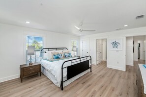 Ein Schlafzimmer mit Bett, Nachttisch und Deckenventilator.