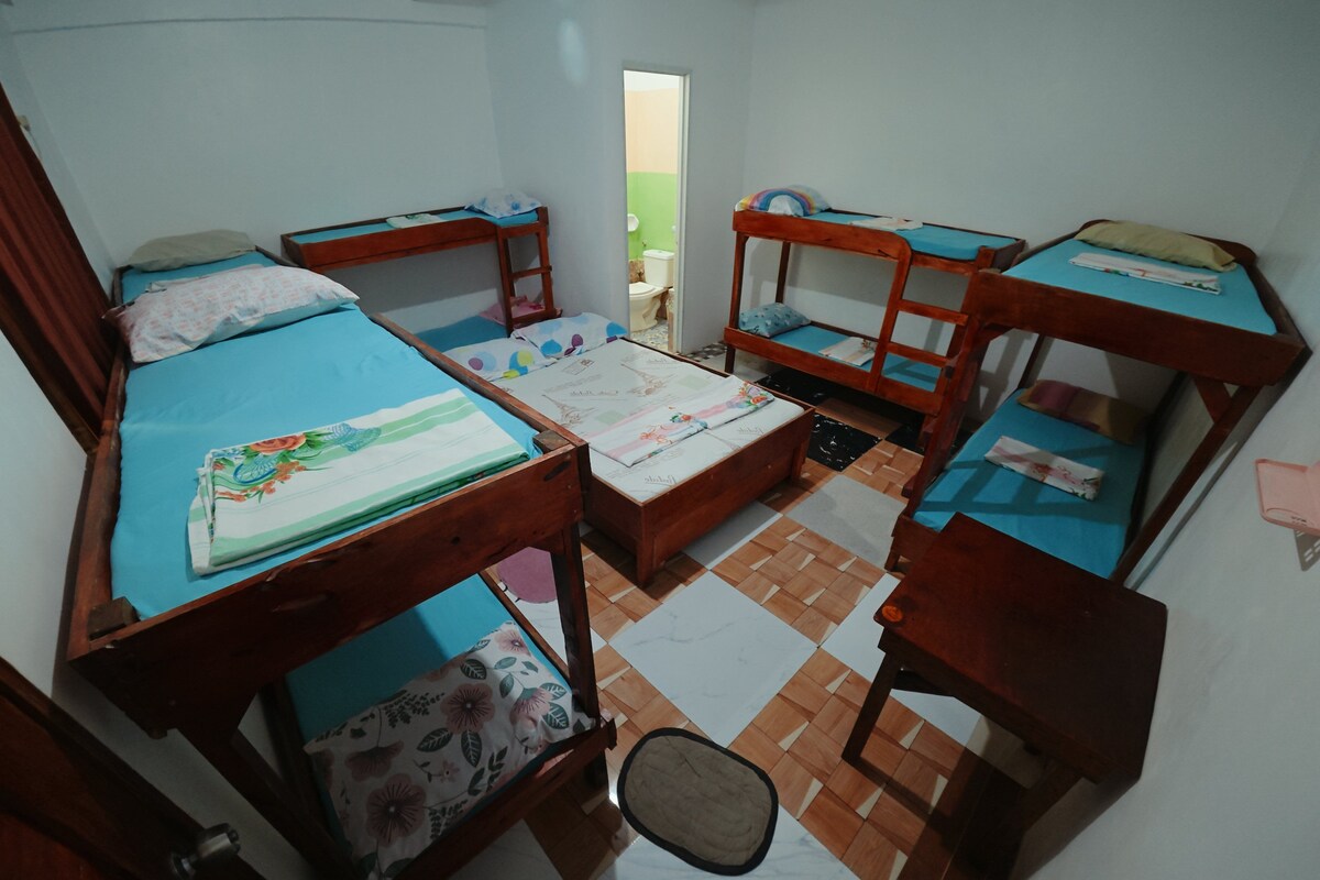 Une chambre de dortoir avec des lits superposés, une petite table et une chaise.