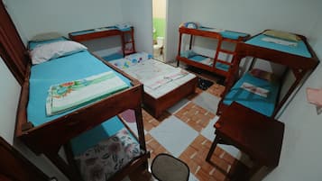 Quarto tipo dormitório com beliches, uma pequena mesa e uma cadeira.