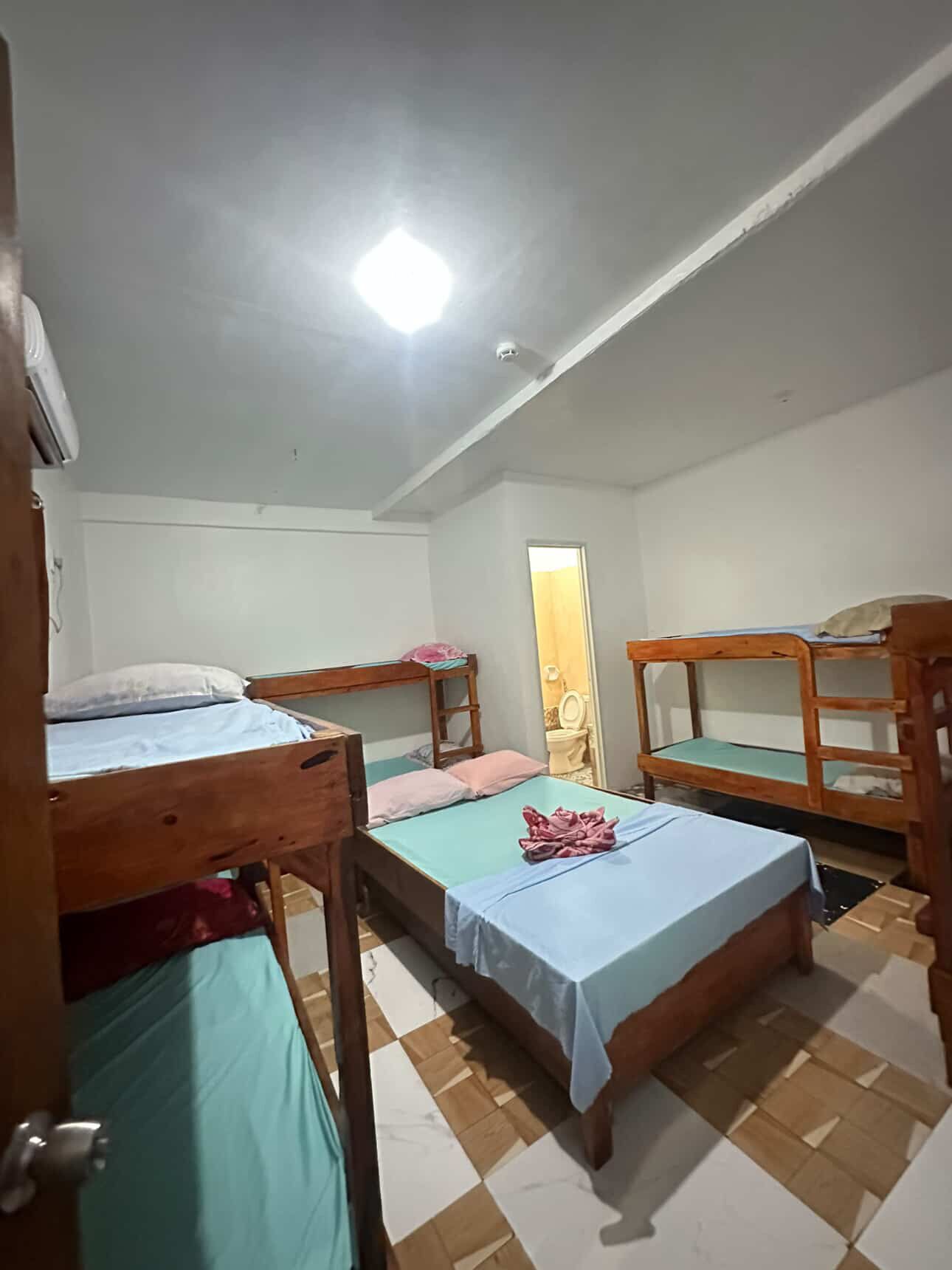 Un dormitorio con literas, una cama individual y una pequeña mesa.