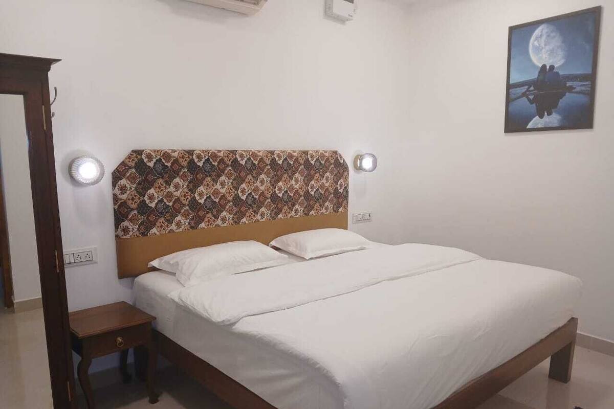 Un dormitorio con una cama de madera, una mesita de noche, un espejo y un cuadro colgado en la pared.