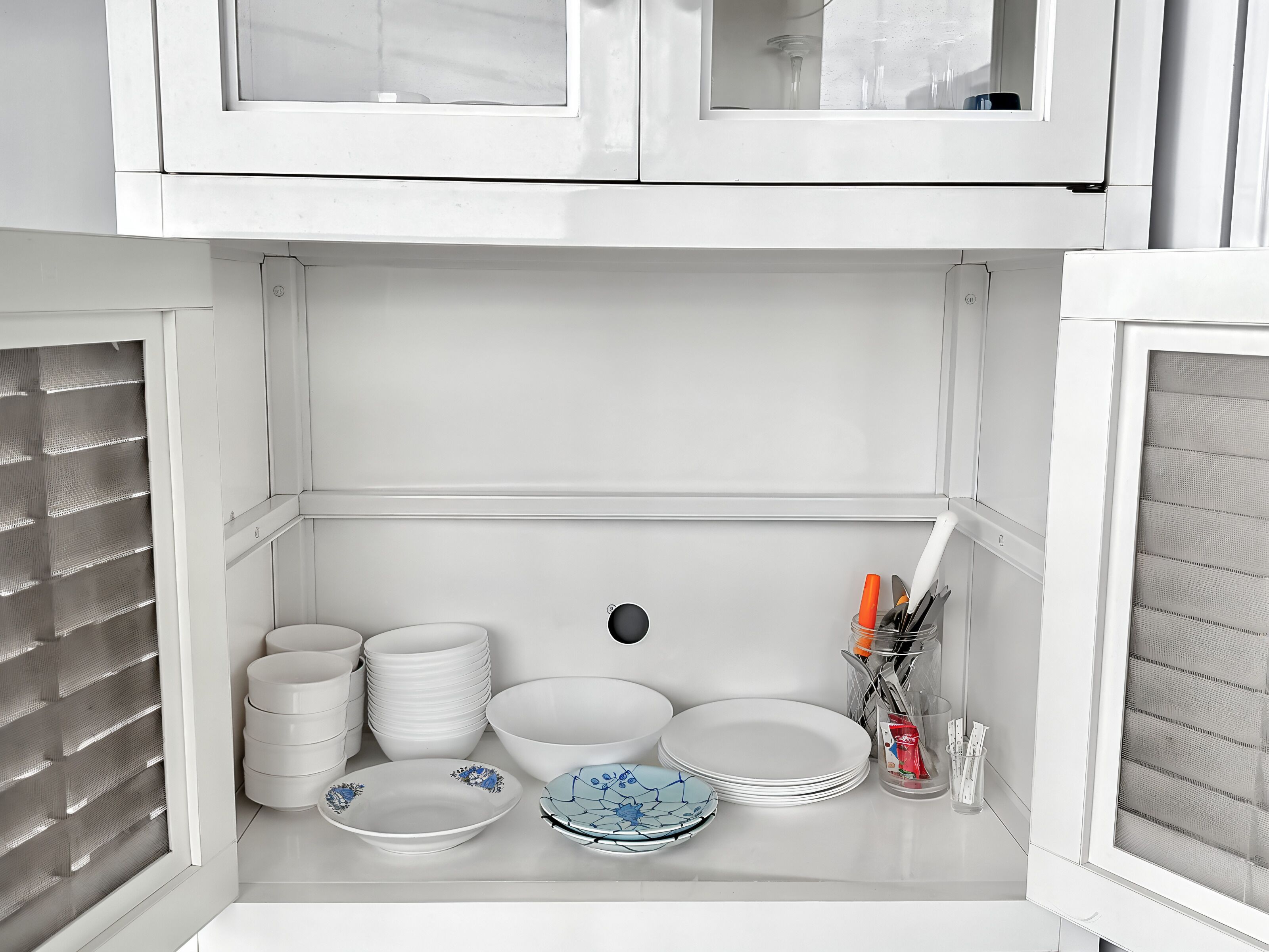 A kitchen with white cabinets, a window, and a sink.