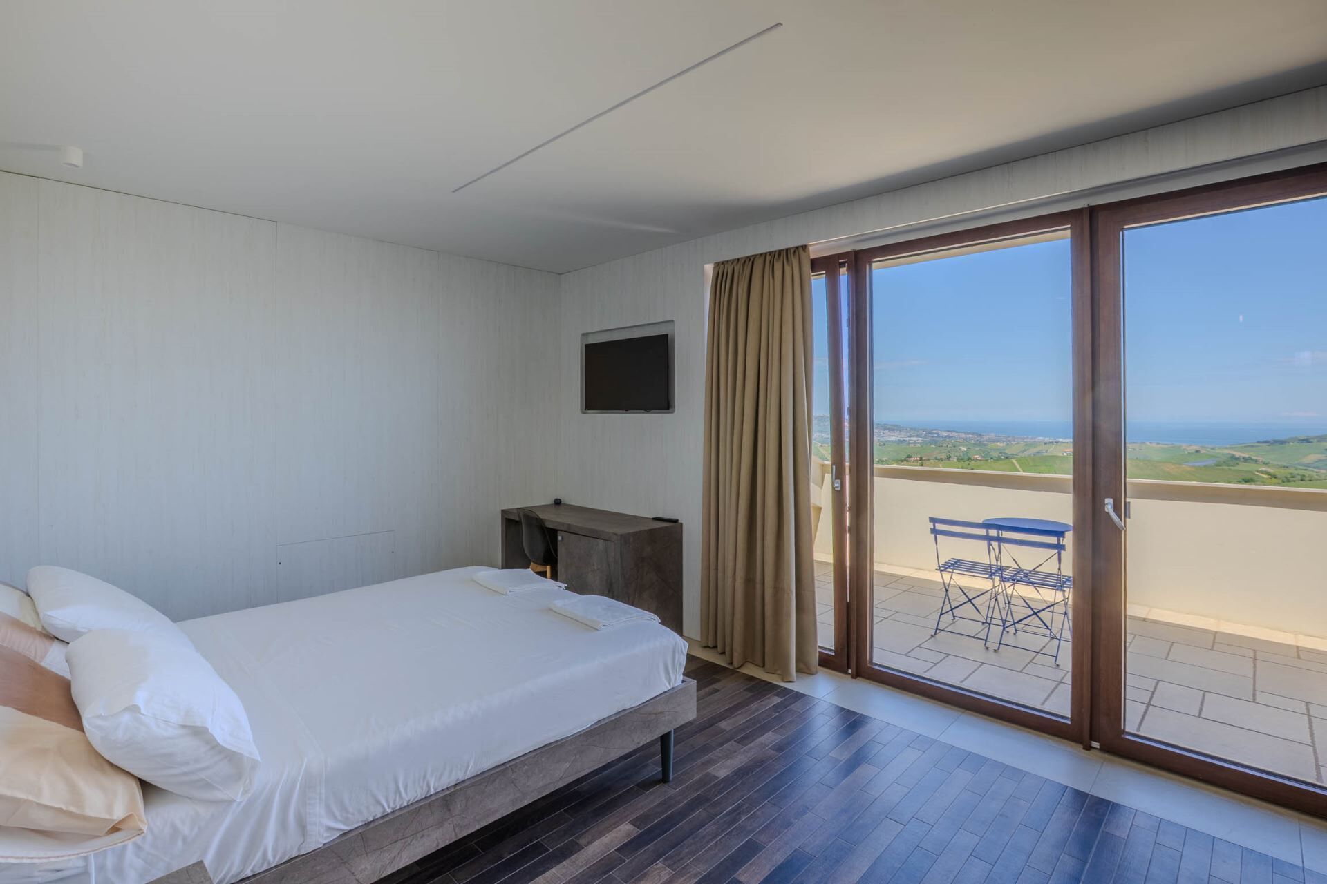 Une chambre avec un lit, un bureau et une vue sur l’extérieur.