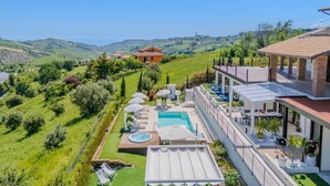 A luxurious villa with a swimming pool, outdoor seating, and a scenic hillside view. - Beautiful villa with pool, SPA and panoramic sea views, just 10 minutes from the beaches of Pineto (Atri)
